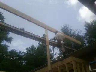 Carpenter setting a ridge beam over a new addition frame — Ice Dam Removal by Roofing Brothers in Peekskill