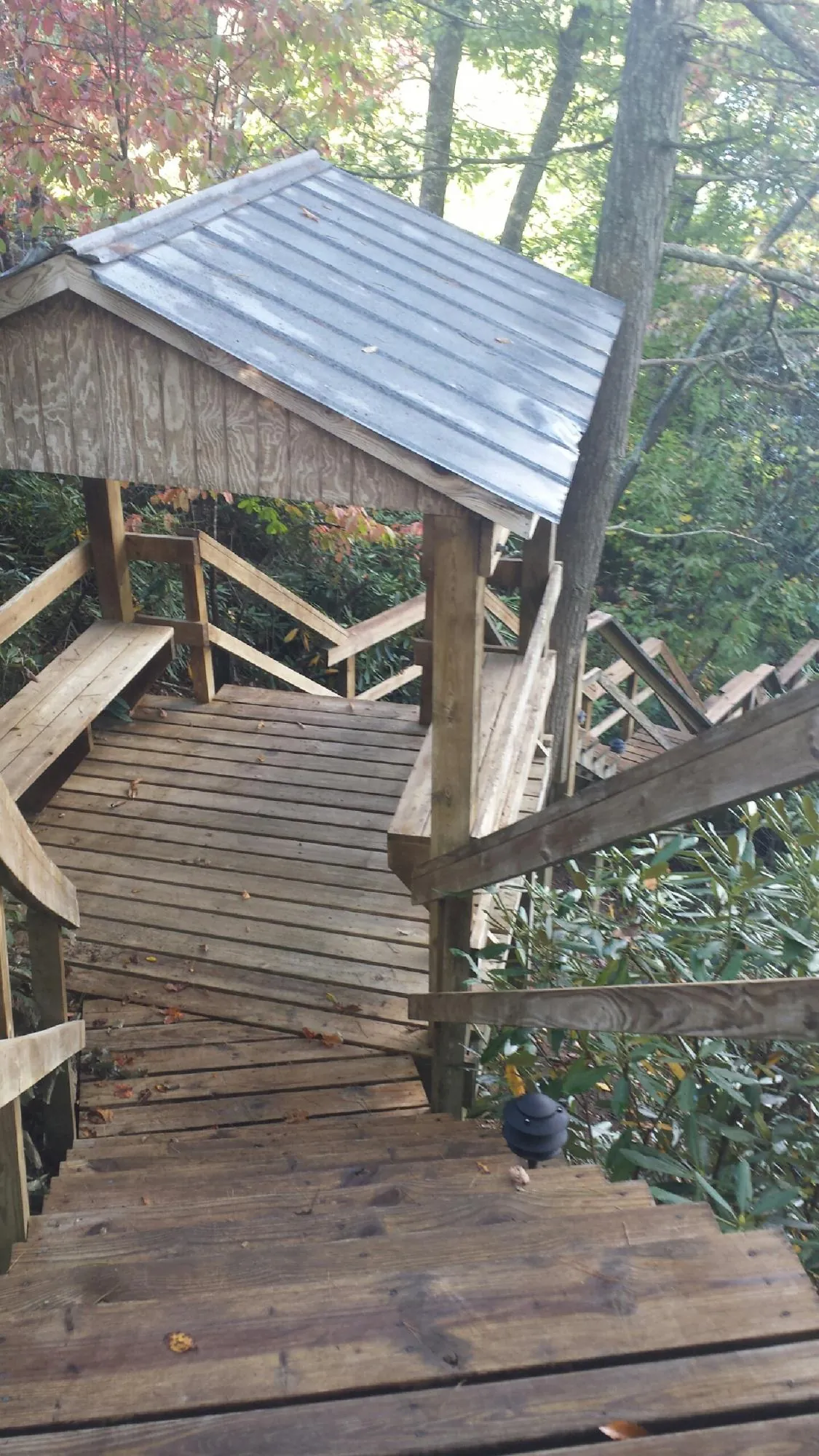 Metal roofed shelter over wooden steps on a wooded walkway — Skylight Repair & Installation work by our crew in Peekskill