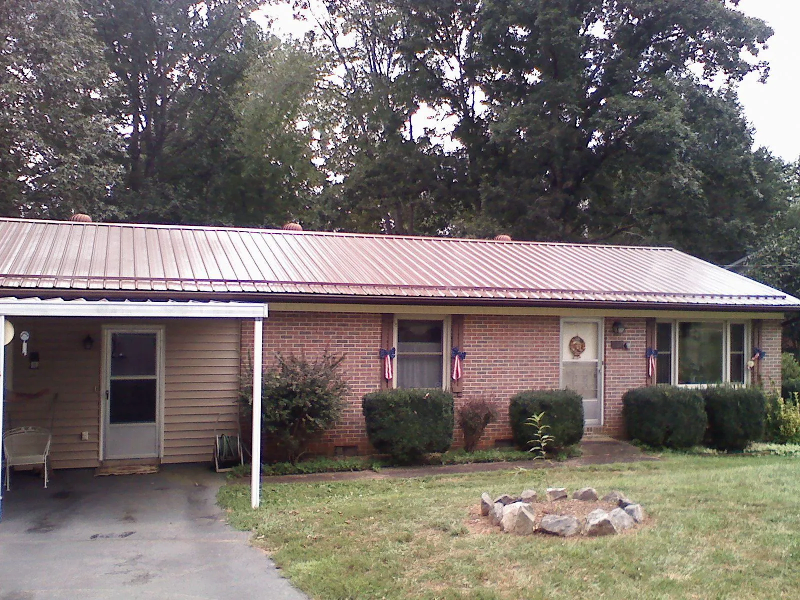 Bronze metal roof and carport on a brick ranch home — Roof Repair work by our crew in Peekskill